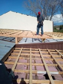A man is standing on top of a wooden structure.