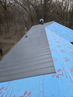 A roof with a blue roofing material on it.