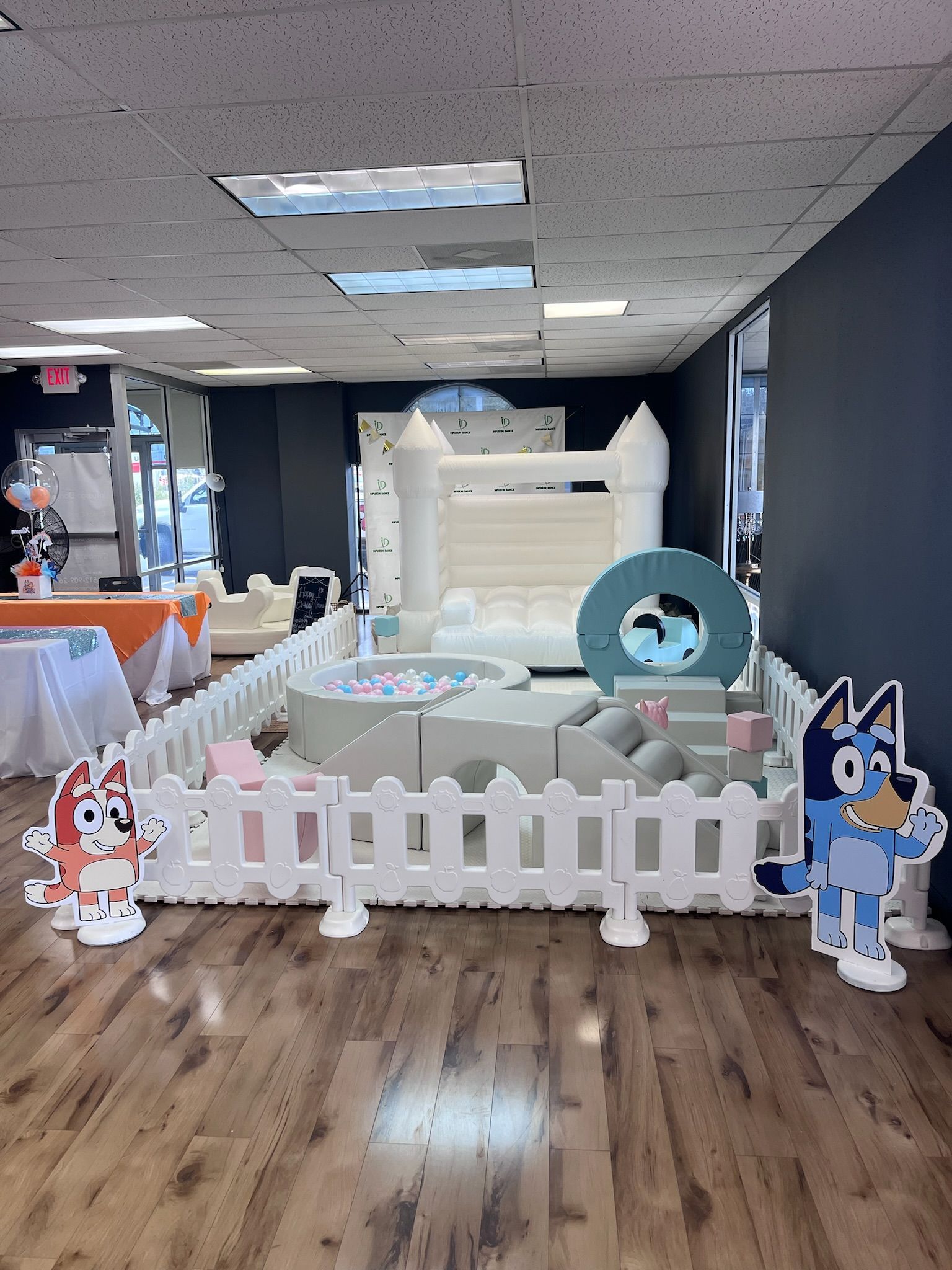 A room with a bouncy house and a fence surrounding it.