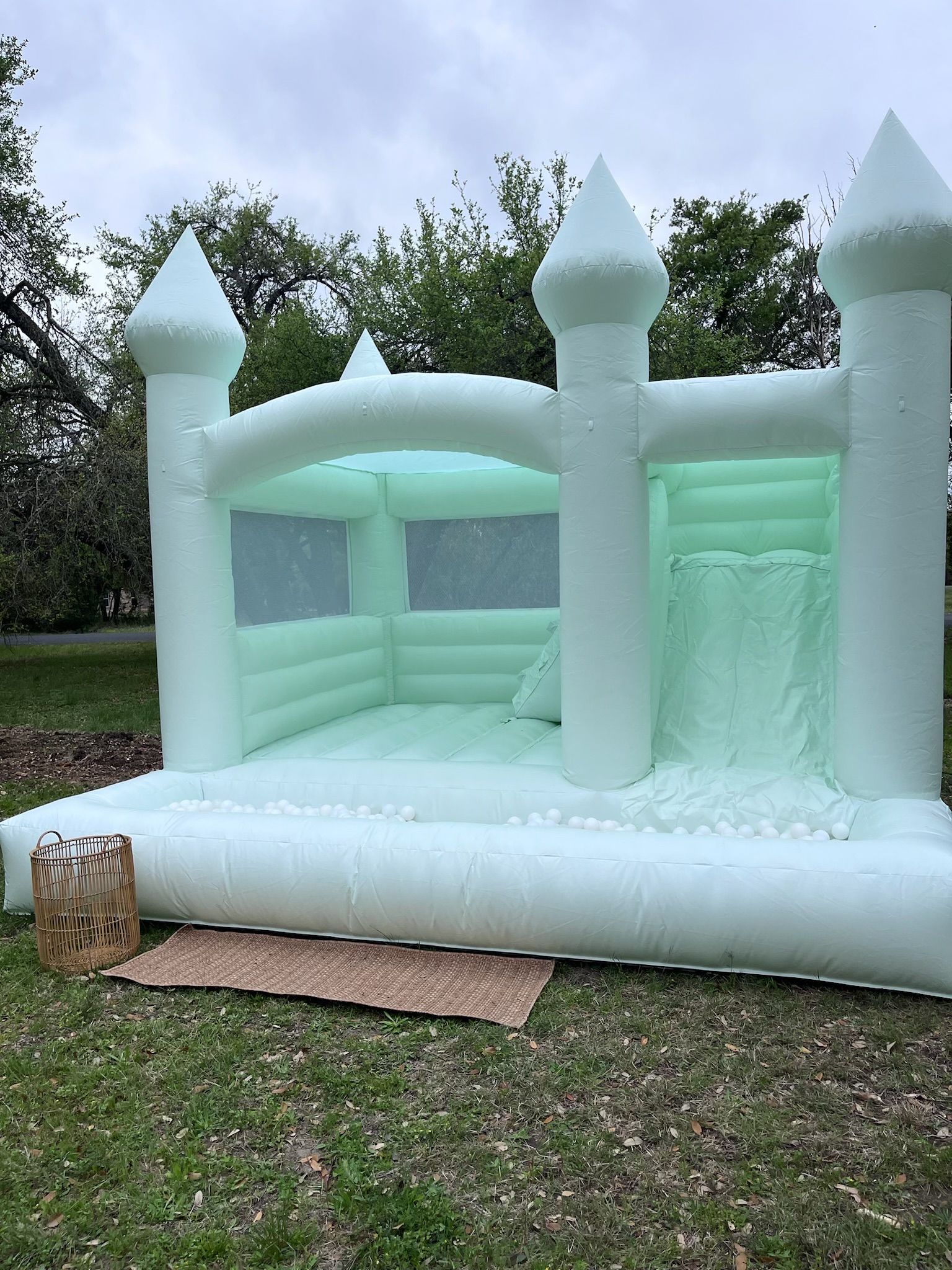 A white bouncy castle is sitting on top of a lush green field.