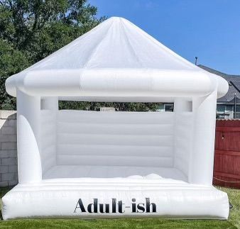 A white bouncy house that says adult ish on it