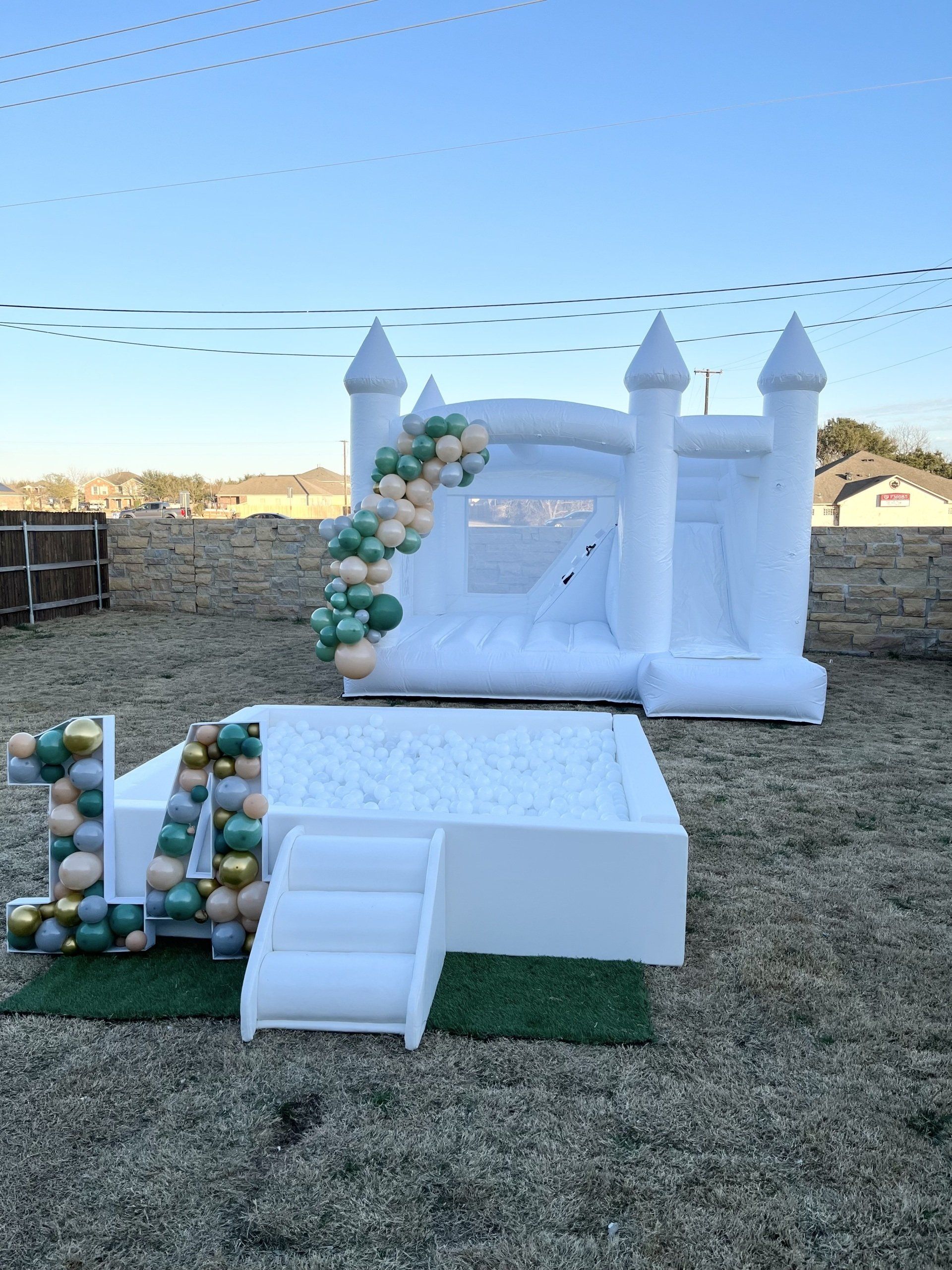 A white bouncy castle is sitting on top of a gravel field.