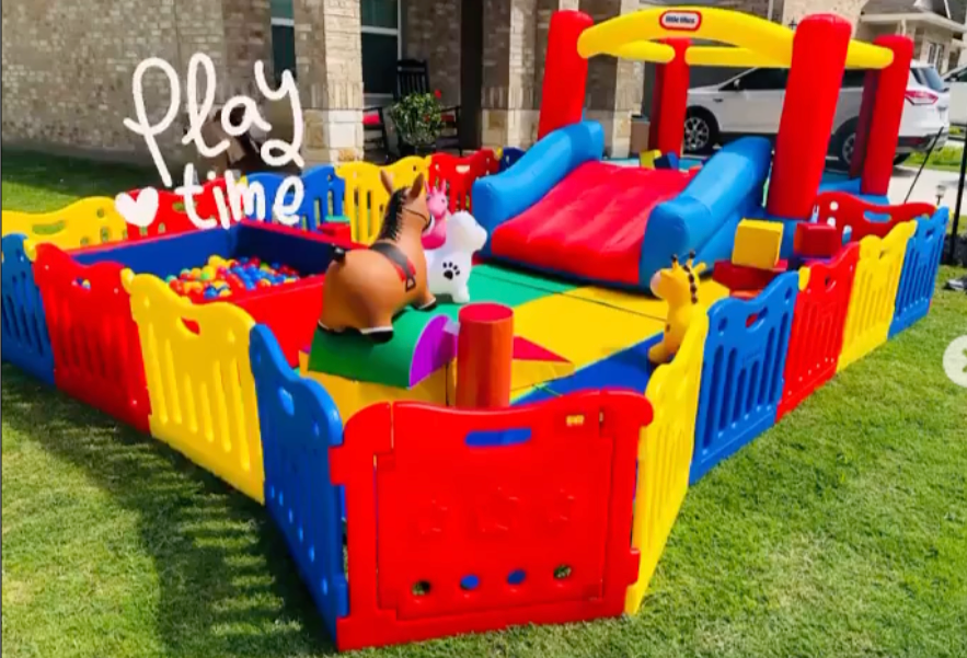 A colorful playground with a bouncy house and a horse.