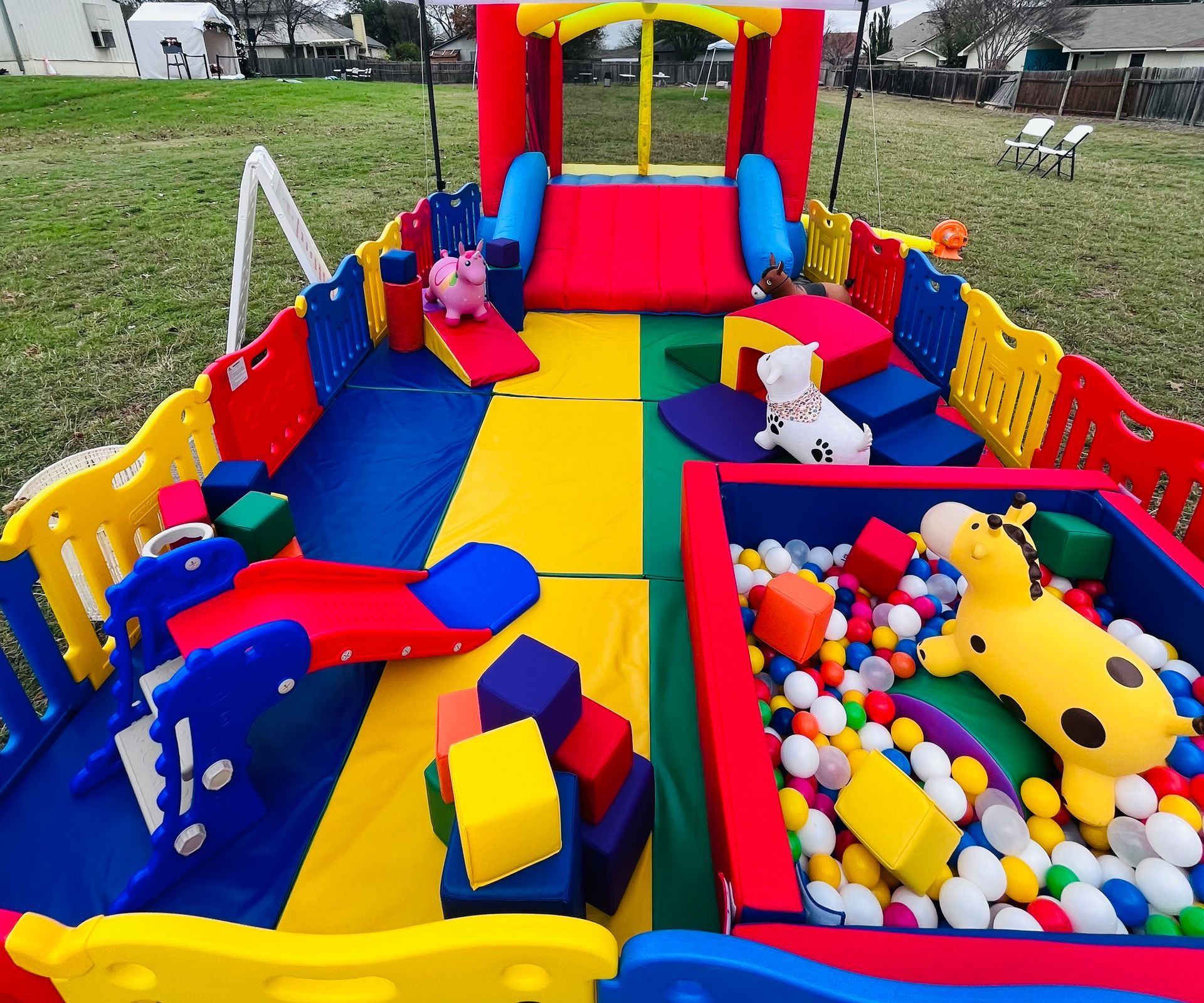 soft play multi color set up of green,yellow,red, and blue. Displaying our ball pit, soft play slide, foam blocks, animal bouncers and bounce house 
