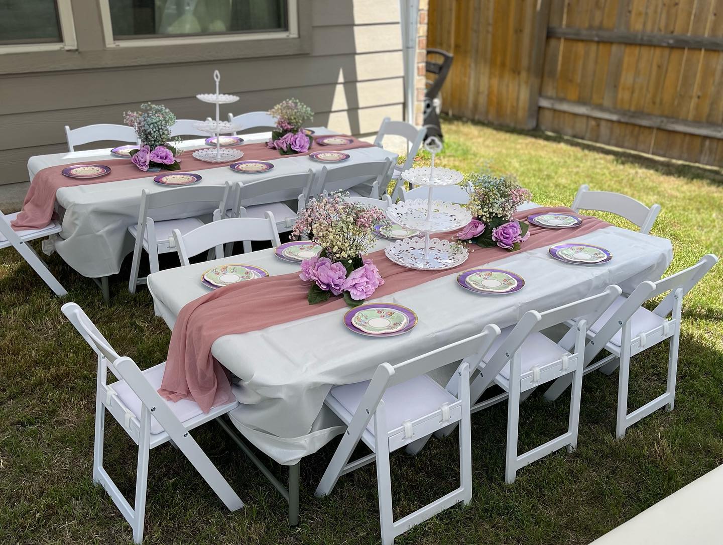 A table and chairs are set up for a party in the backyard.