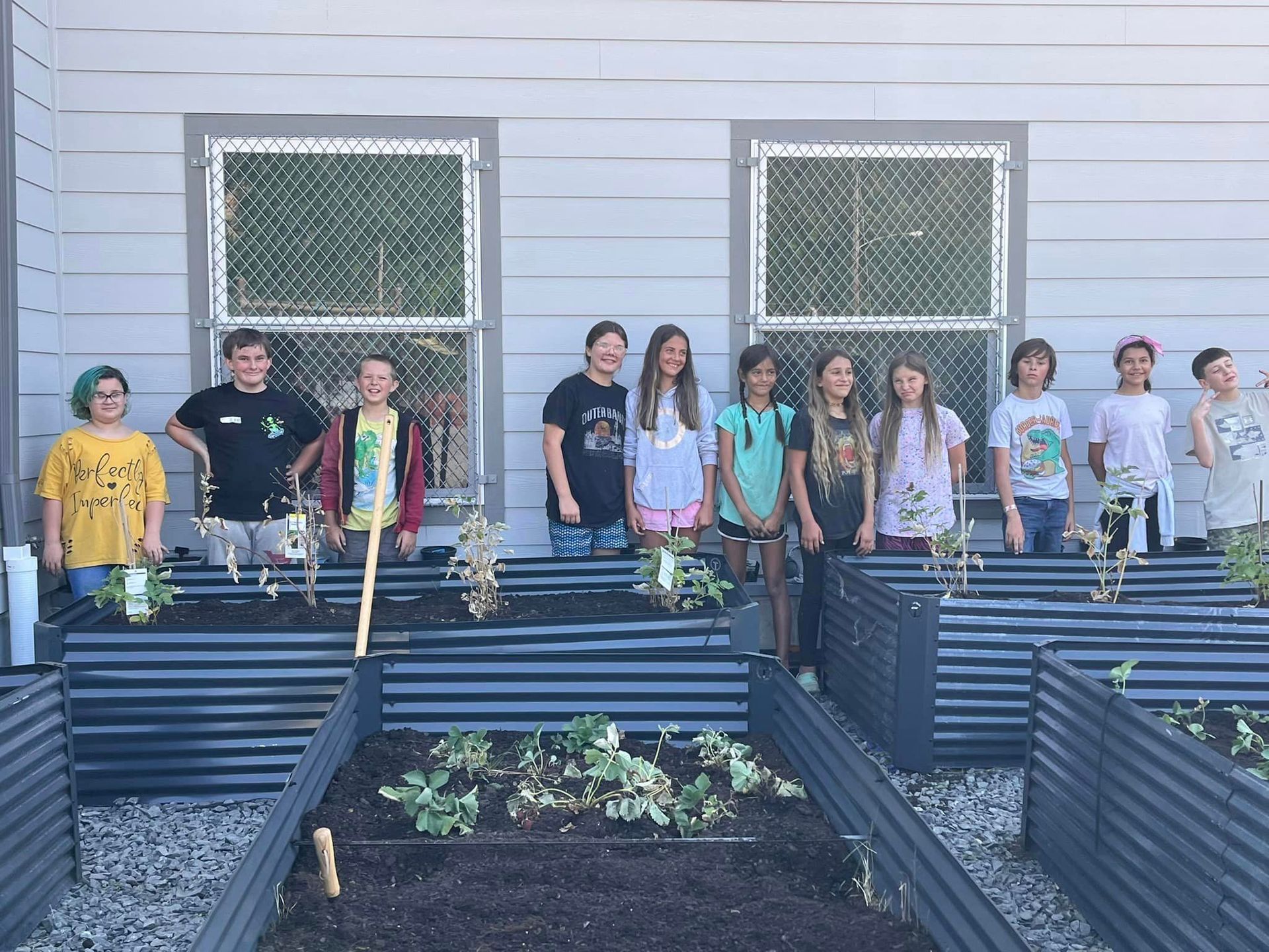 a group of children are sitting in front of a welcome sign