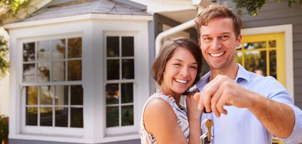 A couple in front of a house holding keys | Illinois Locksmith Services