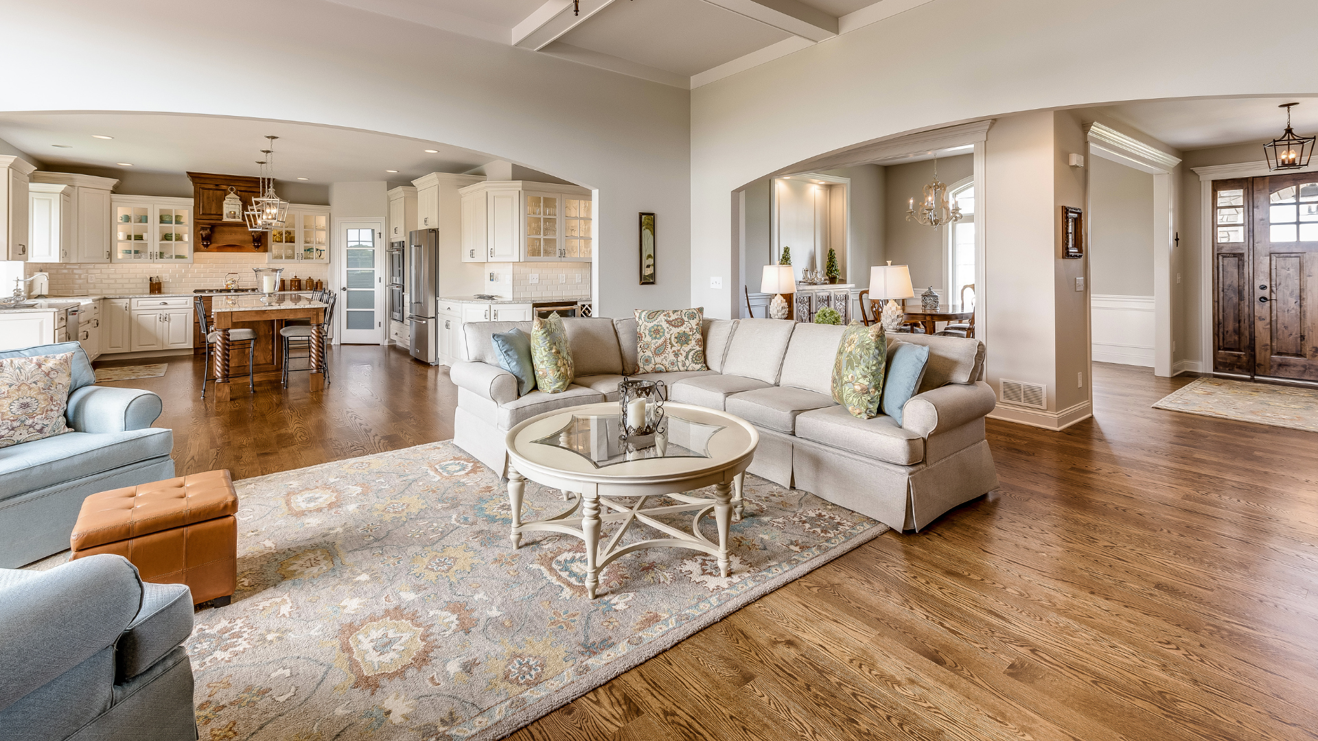 Spacious living room with open kitchen, light colors, hardwood floors, and a welcoming atmosphere.