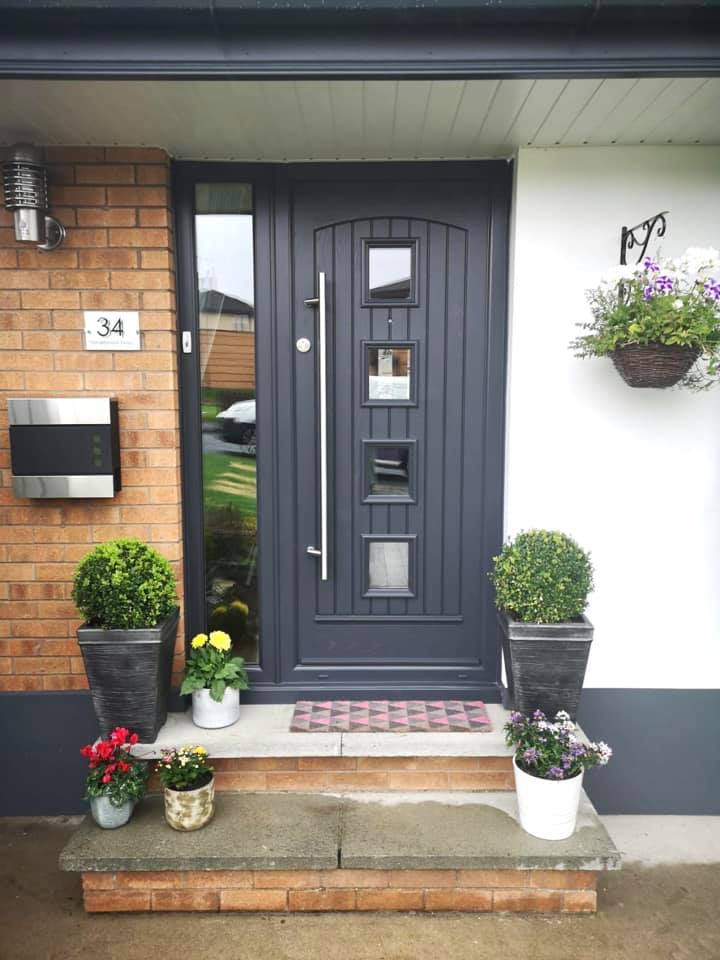 The front door of a house with potted plants in front of it.