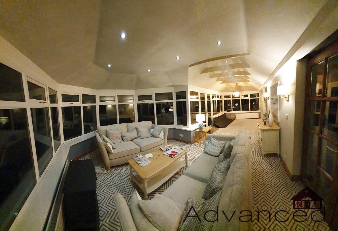 A living room with a lot of furniture and a lot of windows