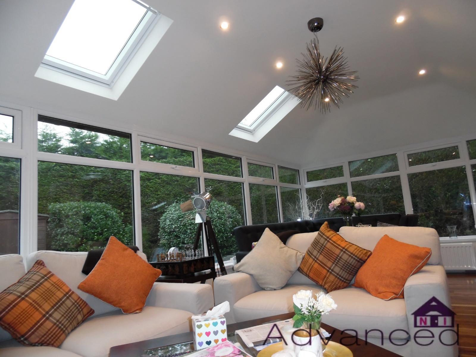 A living room with a white couch and orange pillows