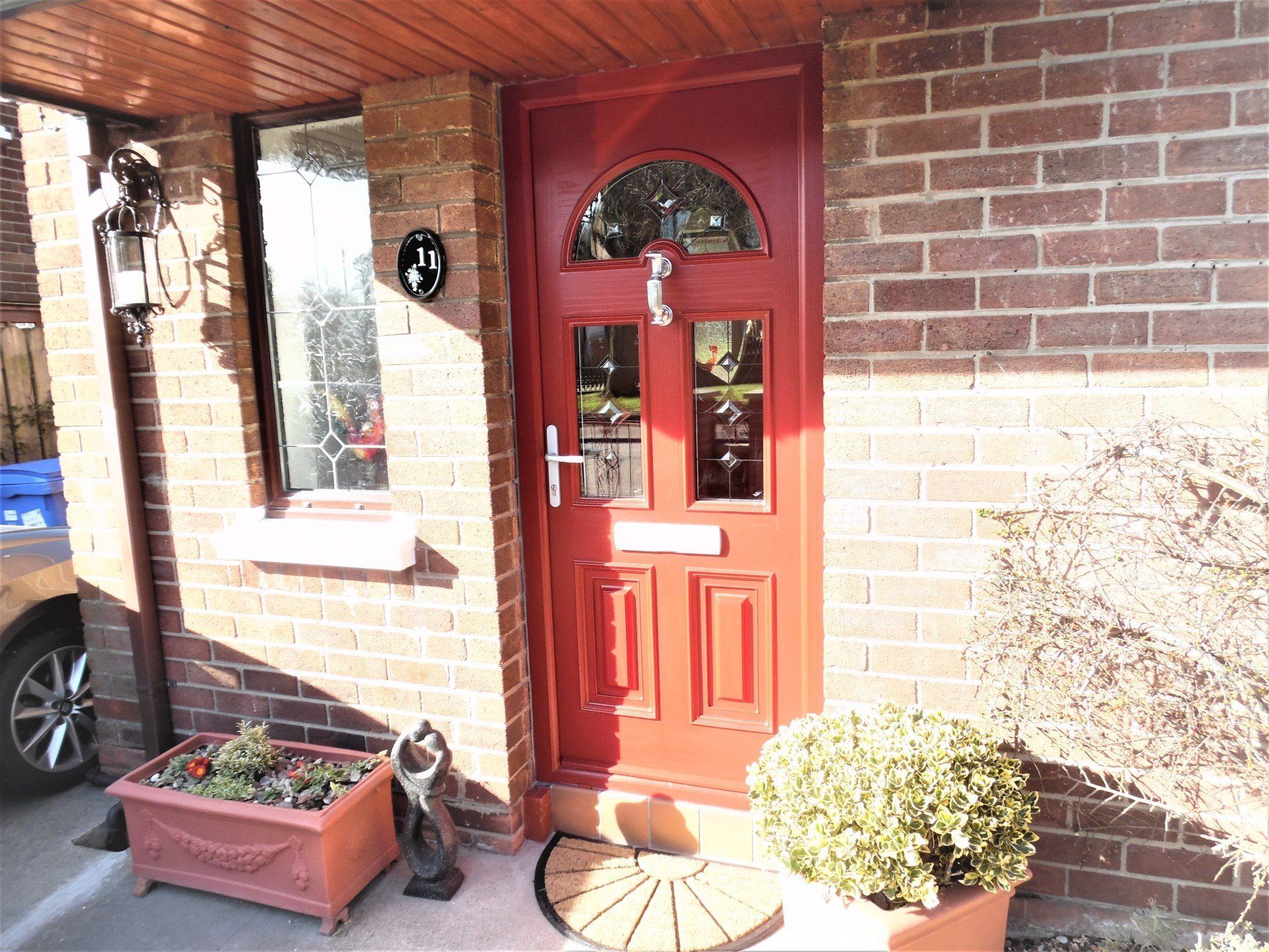 The front door of a brick house with a red door