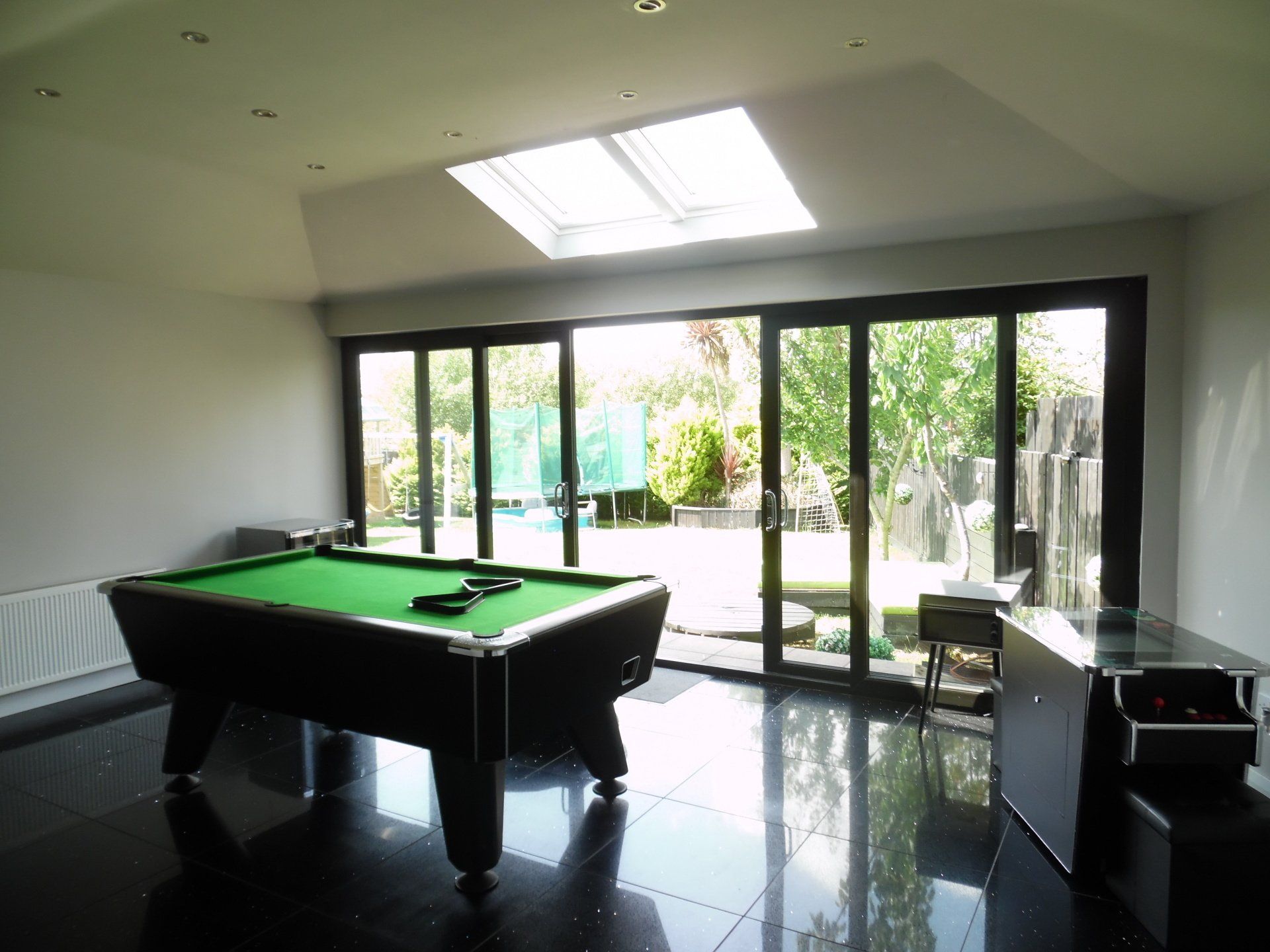 A pool table in a room with a lot of windows