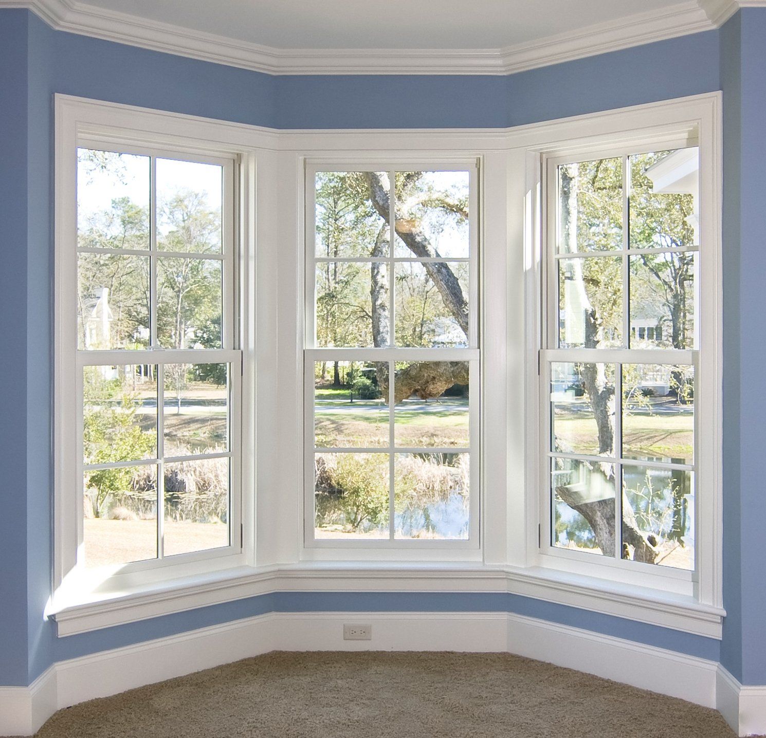 A room with a bay window and blue walls