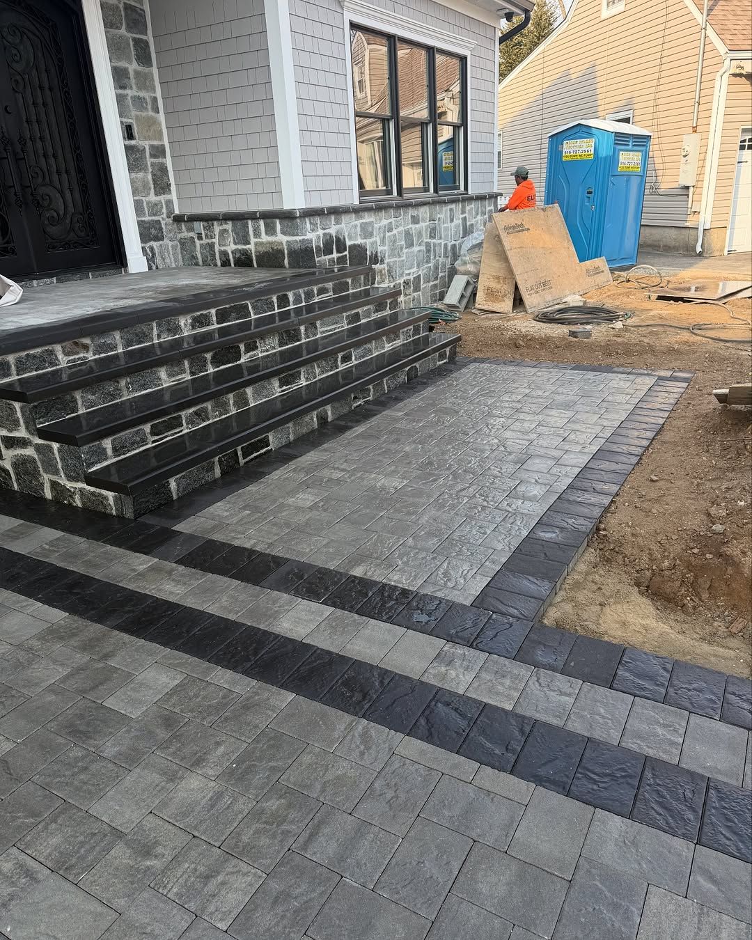 A brick walkway is being built in front of a house.