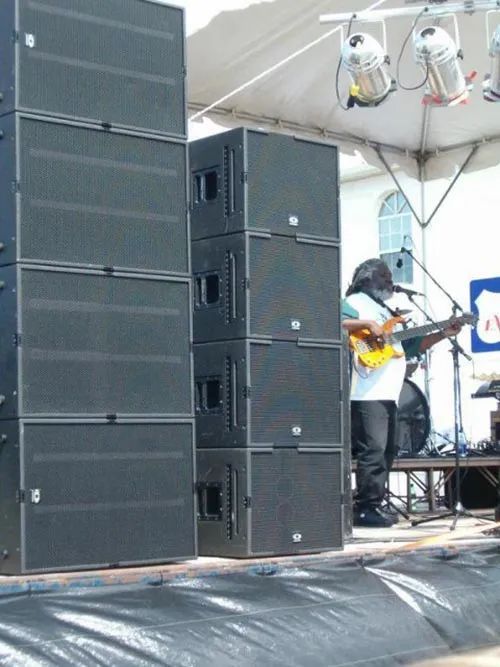 A man playing a guitar in front of a stack of speakers