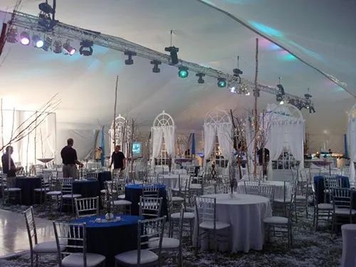 A large room with tables and chairs under a tent