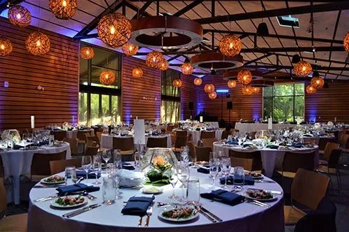 A large room with tables and chairs set up for a wedding reception.