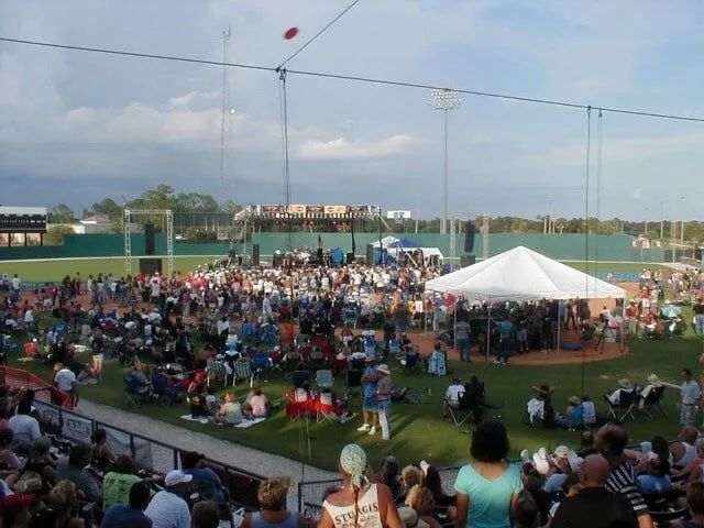 A large crowd of people are gathered at a baseball field