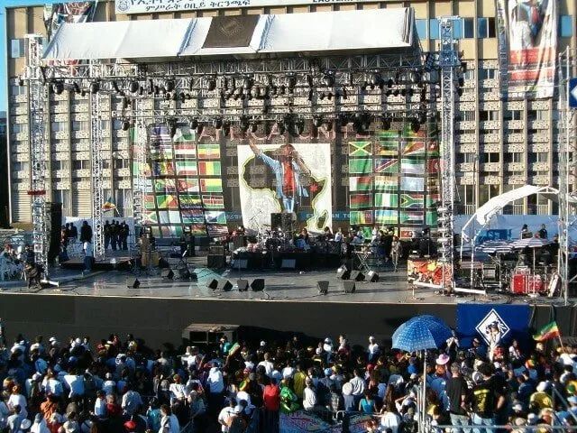 A large crowd of people are gathered in front of a large stage