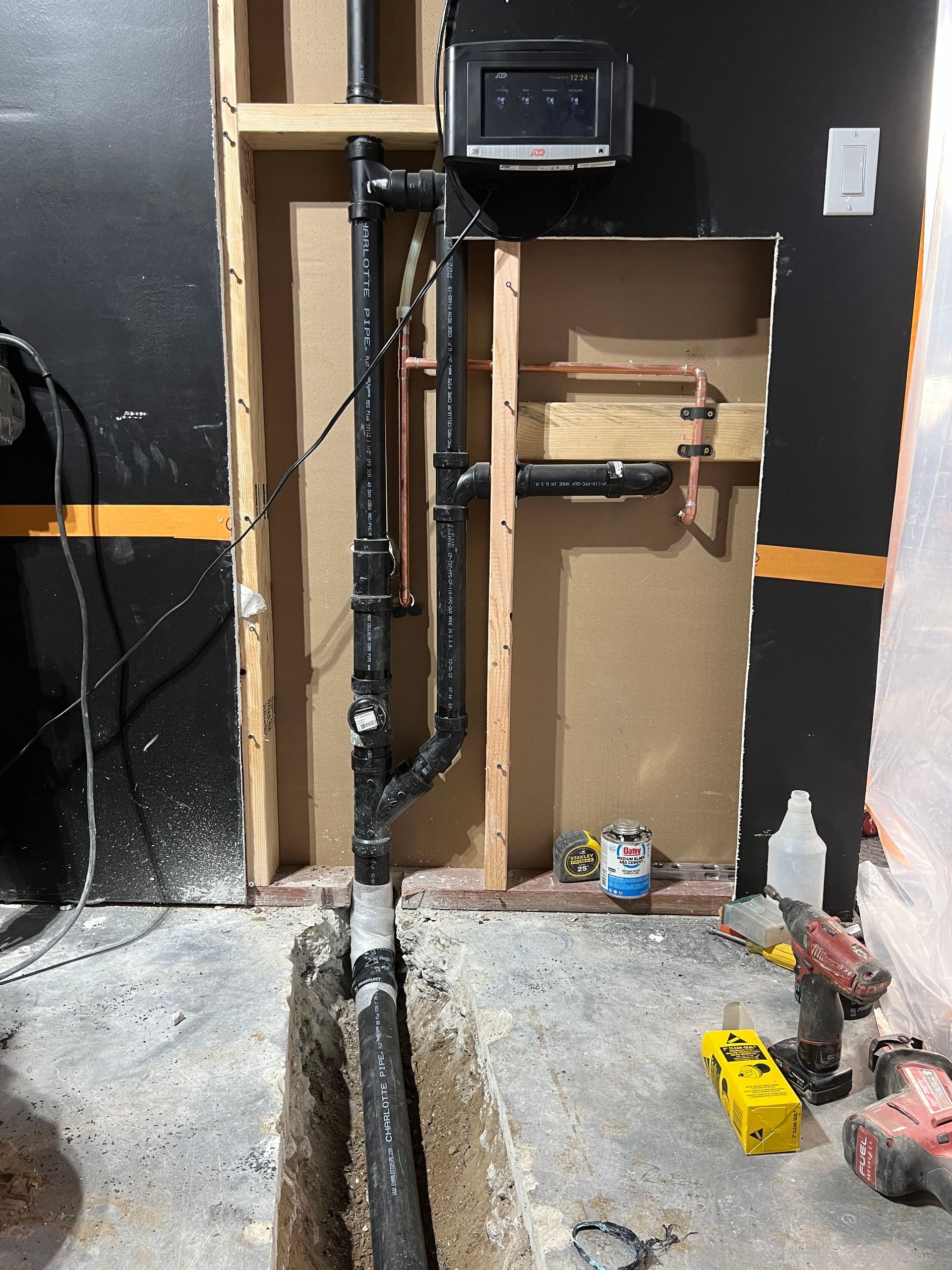 a thermostat is mounted to a wall next to some pipes