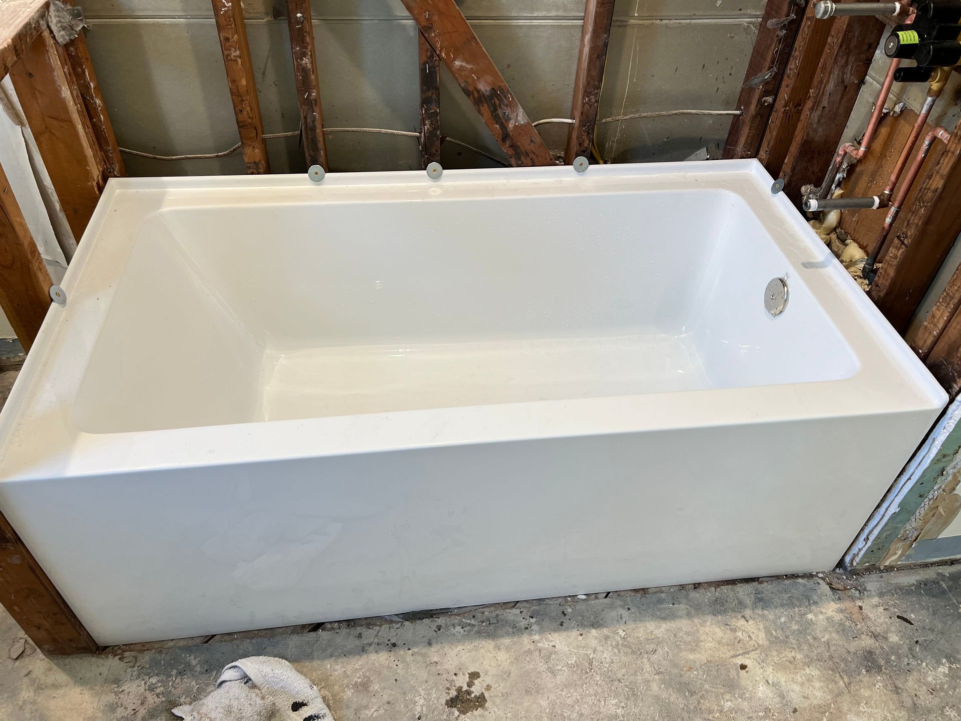 a white bathtub is sitting on a concrete floor