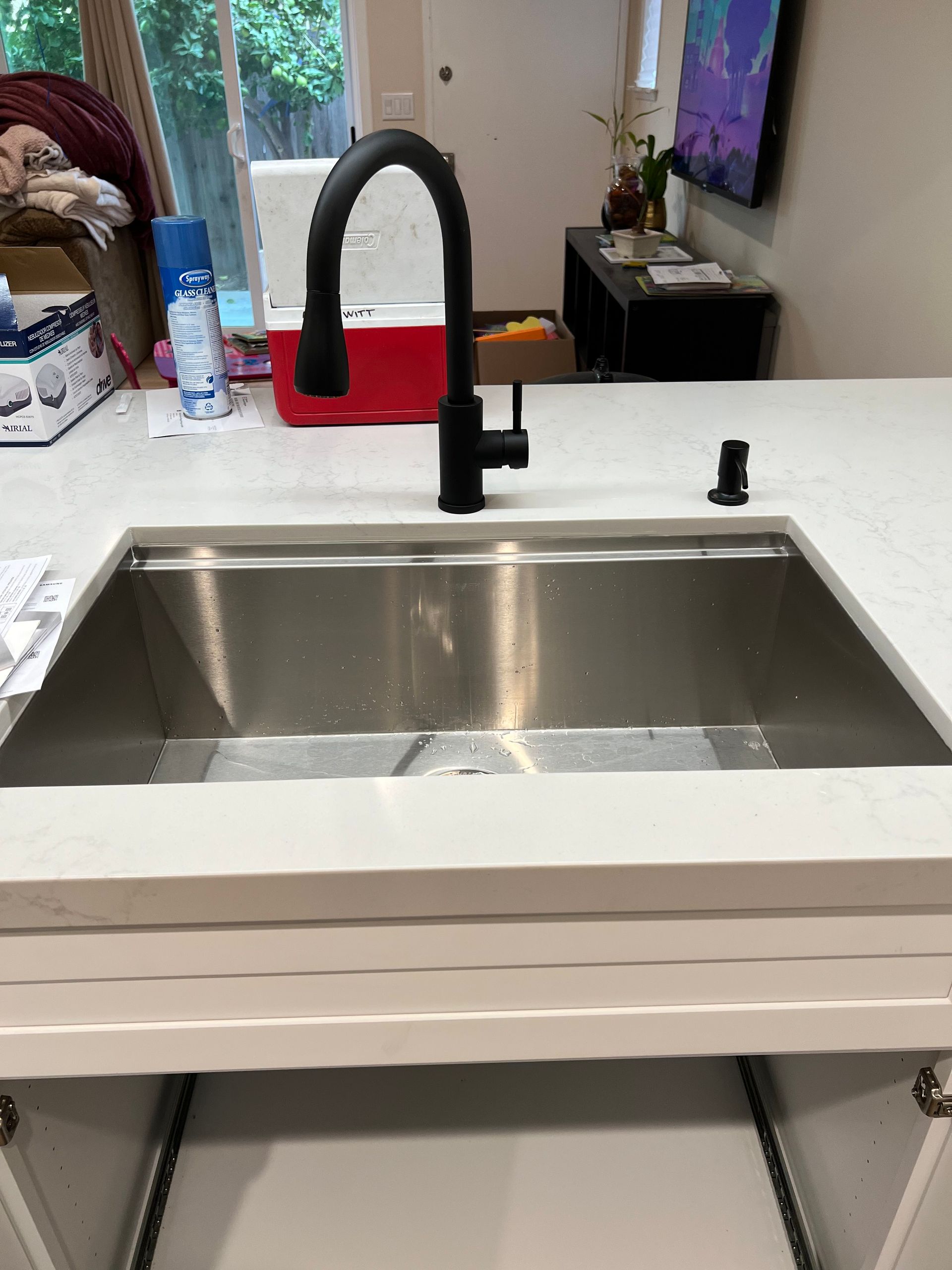 a stainless steel kitchen sink with a black faucet