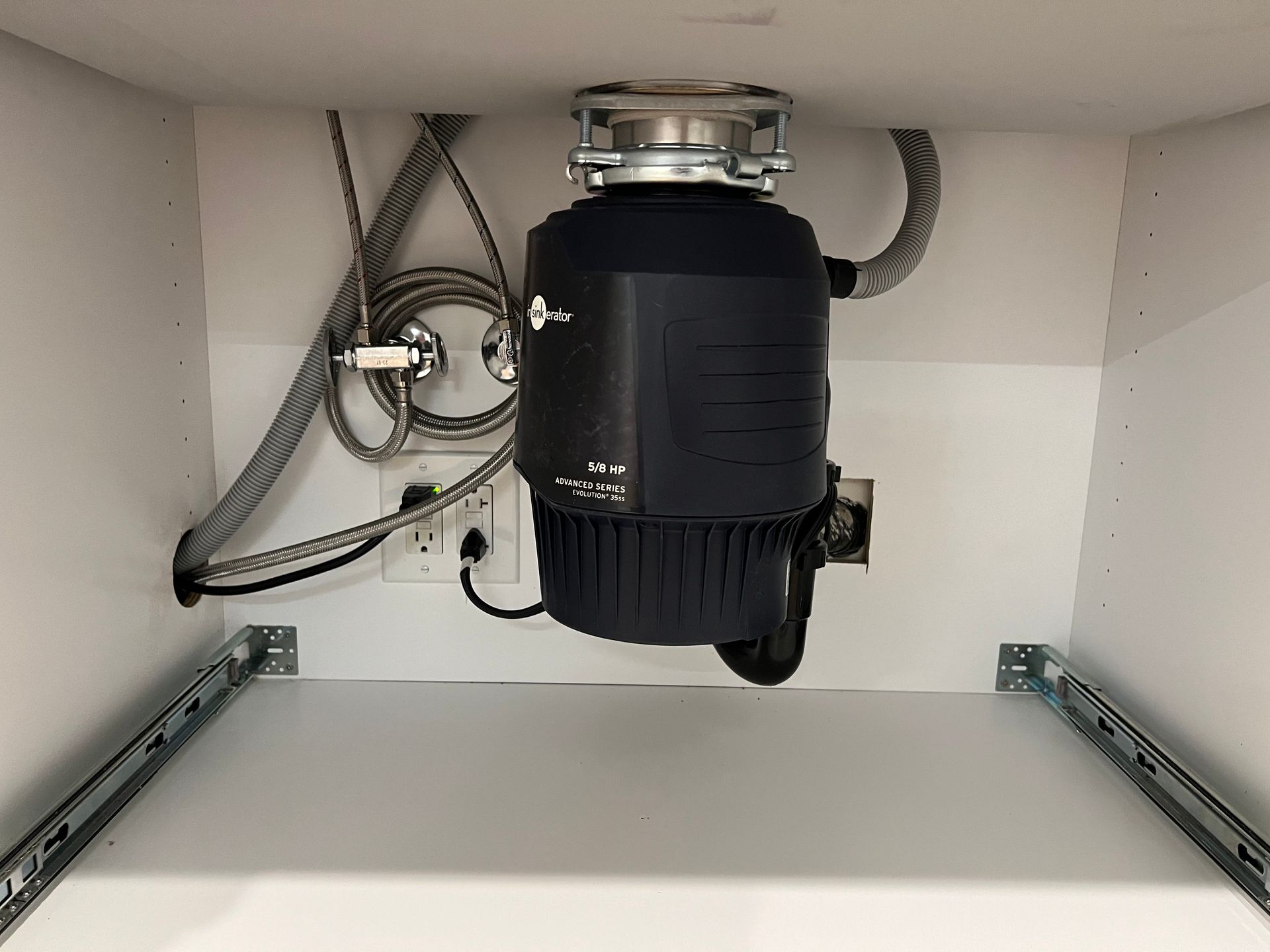 a stainless steel garbage disposal is under a sink