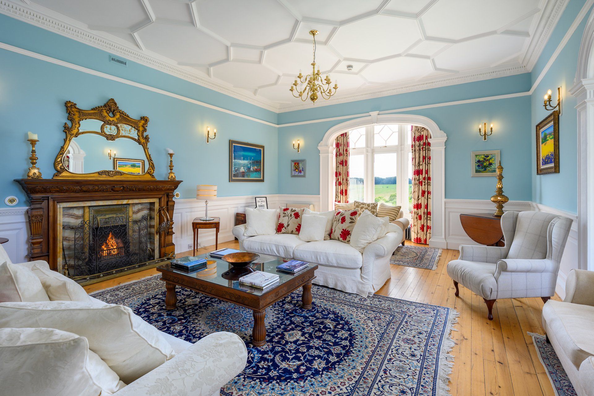 A living room with blue walls and a fireplace