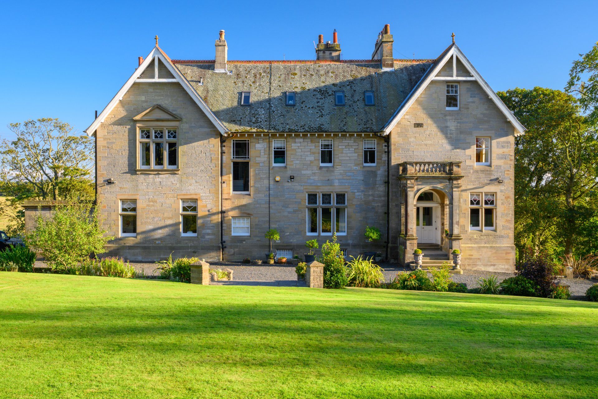 A large house with a lush green lawn in front of it