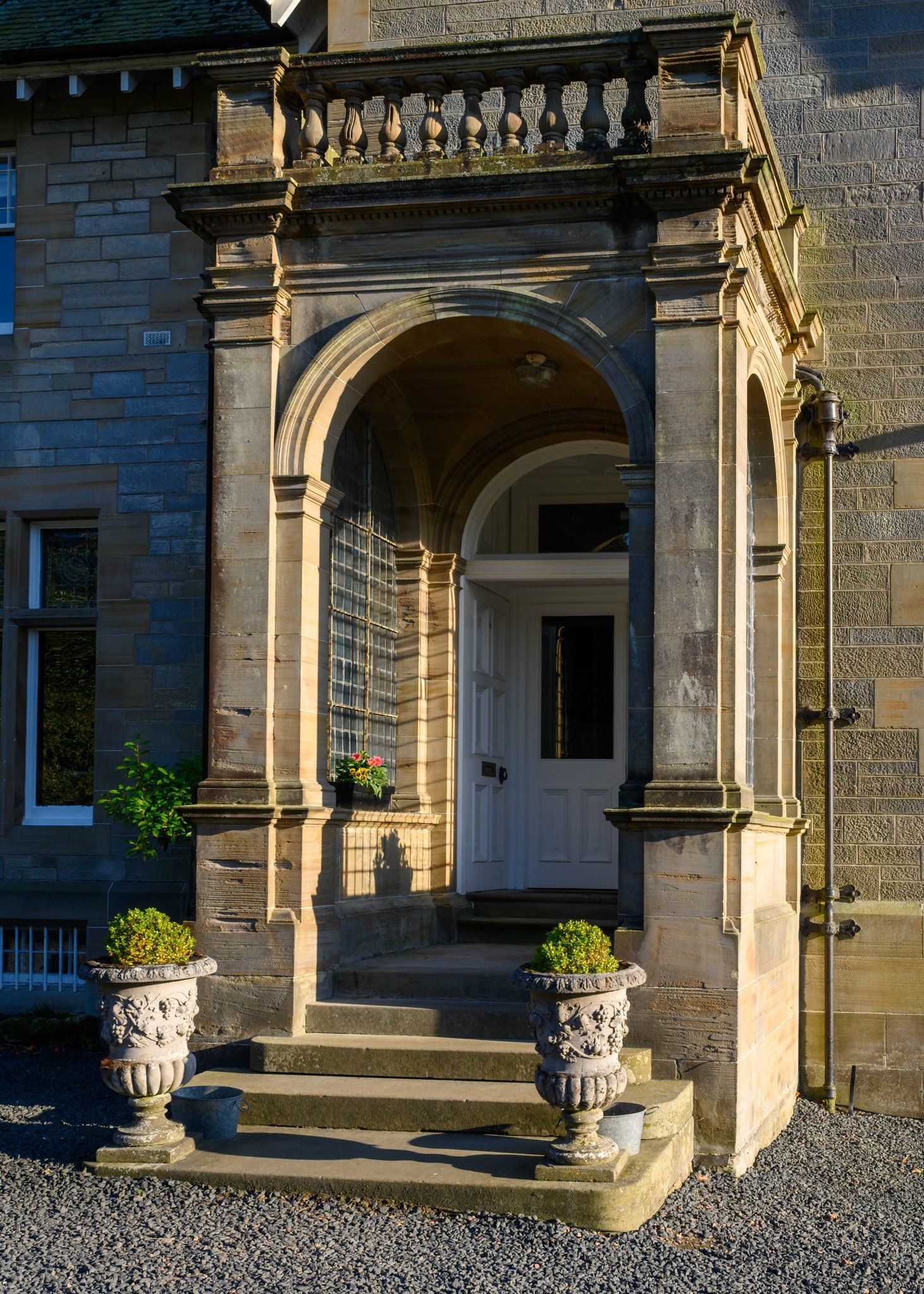 A stone porch with a white door and steps