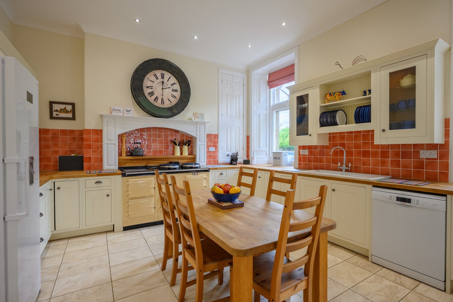 A kitchen with a table and chairs and a clock on the wall