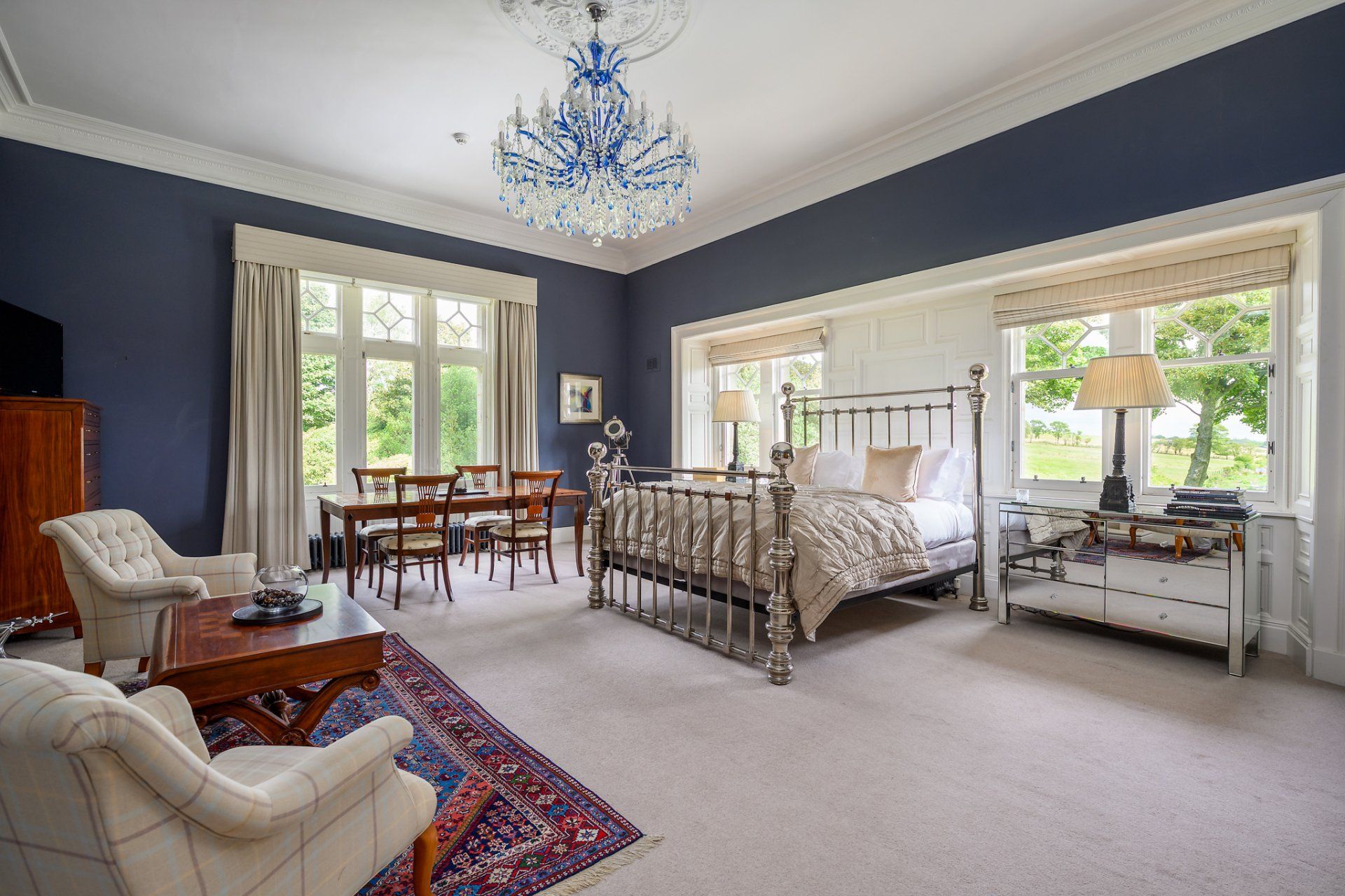 A bedroom with a large bed and a chandelier