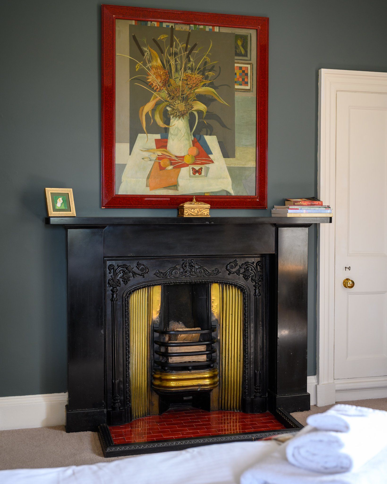A fireplace with a painting on the wall above it
