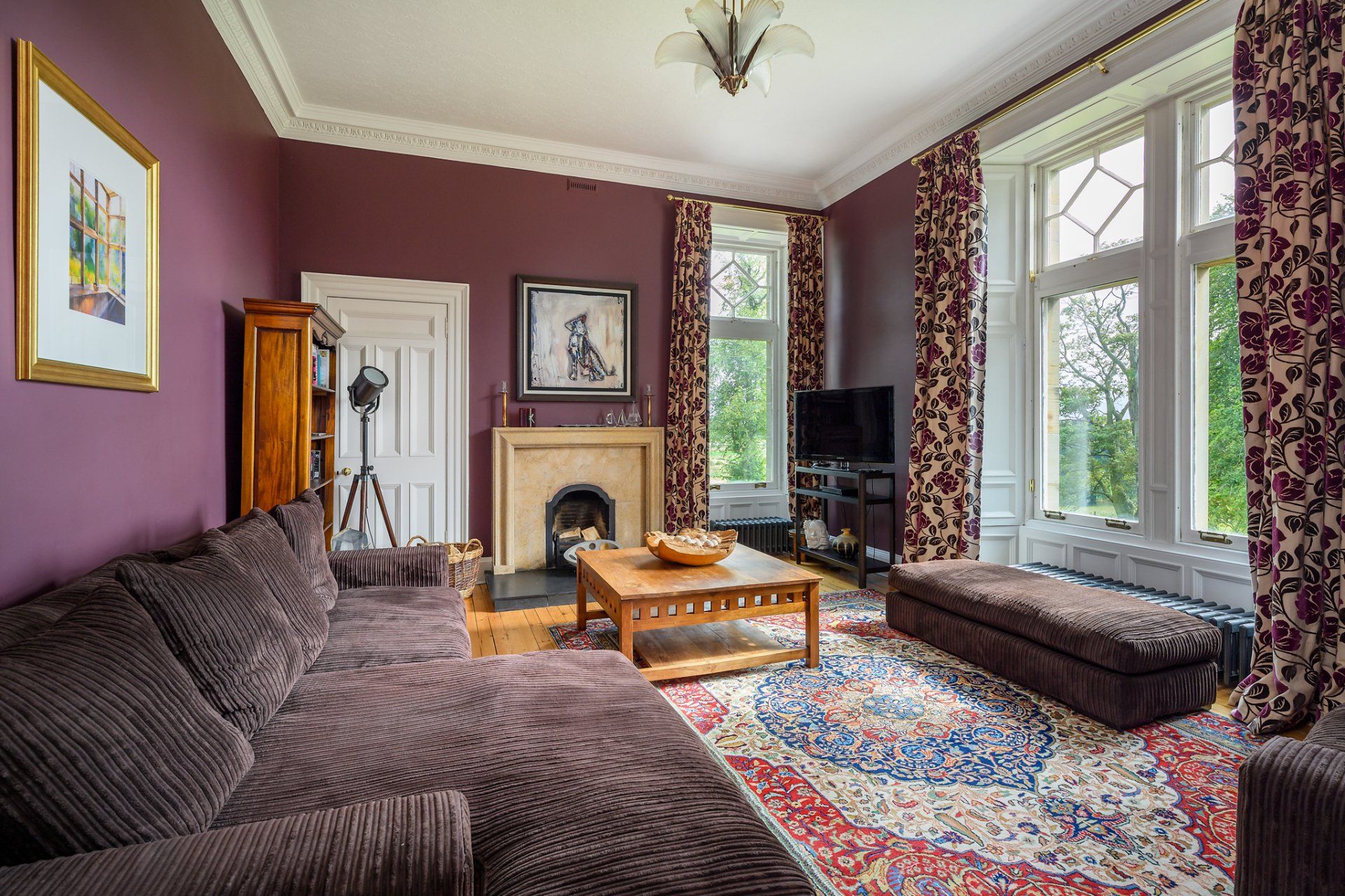 A living room with purple walls and a fireplace