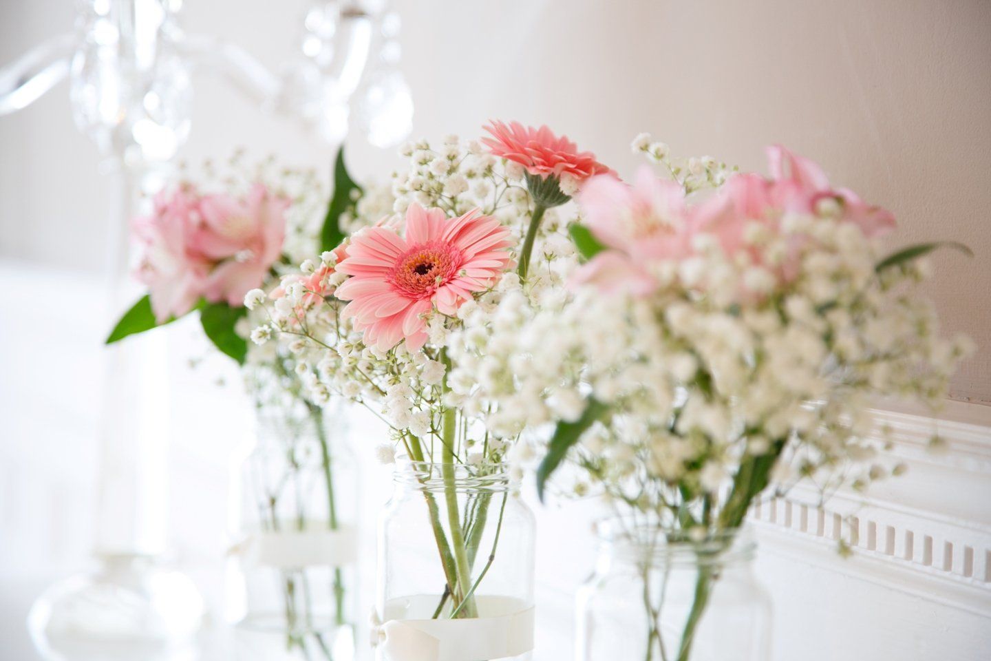 A row of vases filled with pink and white flowers