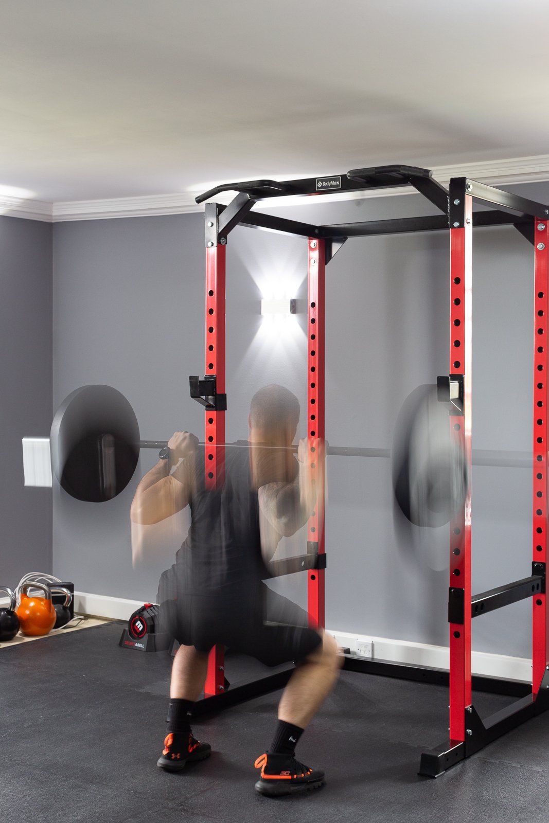 A man squatting with a barbell in a gym