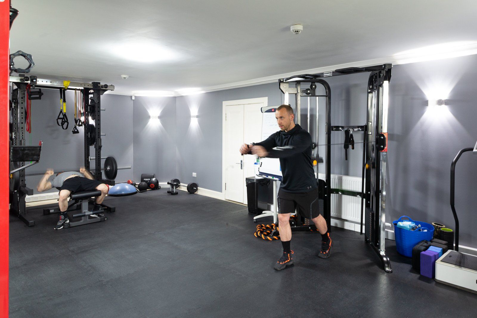 A man is doing squats in a gym