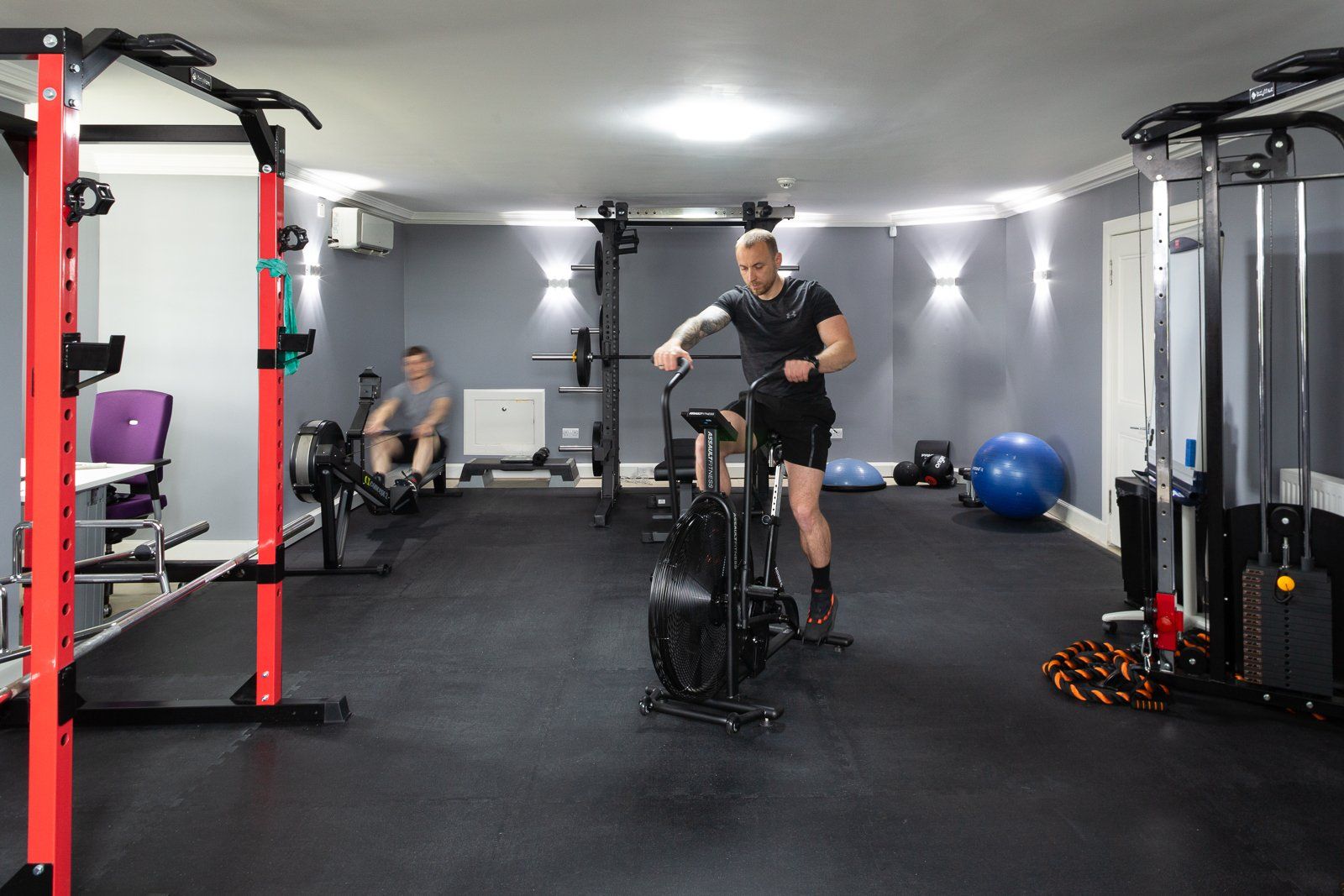 A man is riding an exercise bike in a gym