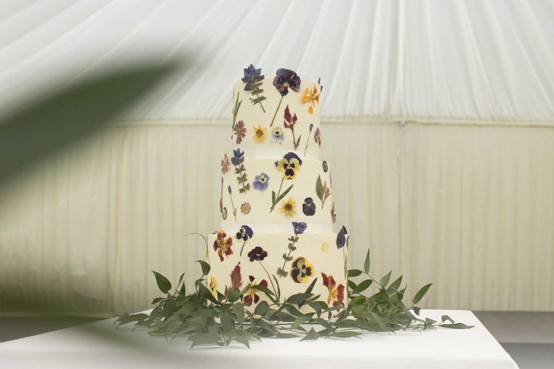 A wedding cake with flowers on it is on a table