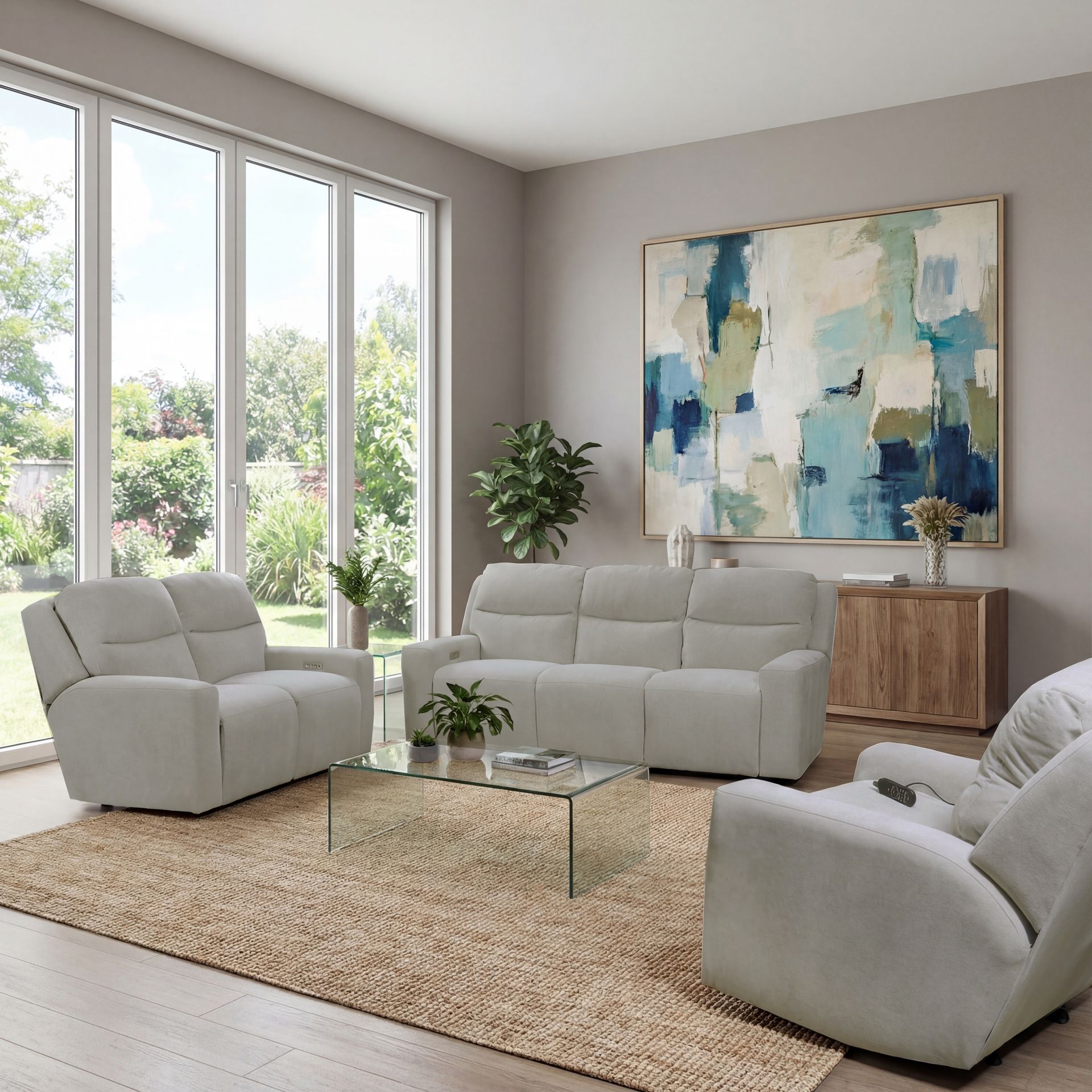 A light gray sofa and loveseat set on a jute rug in a bright, modern living room with abstract art and a glass table.