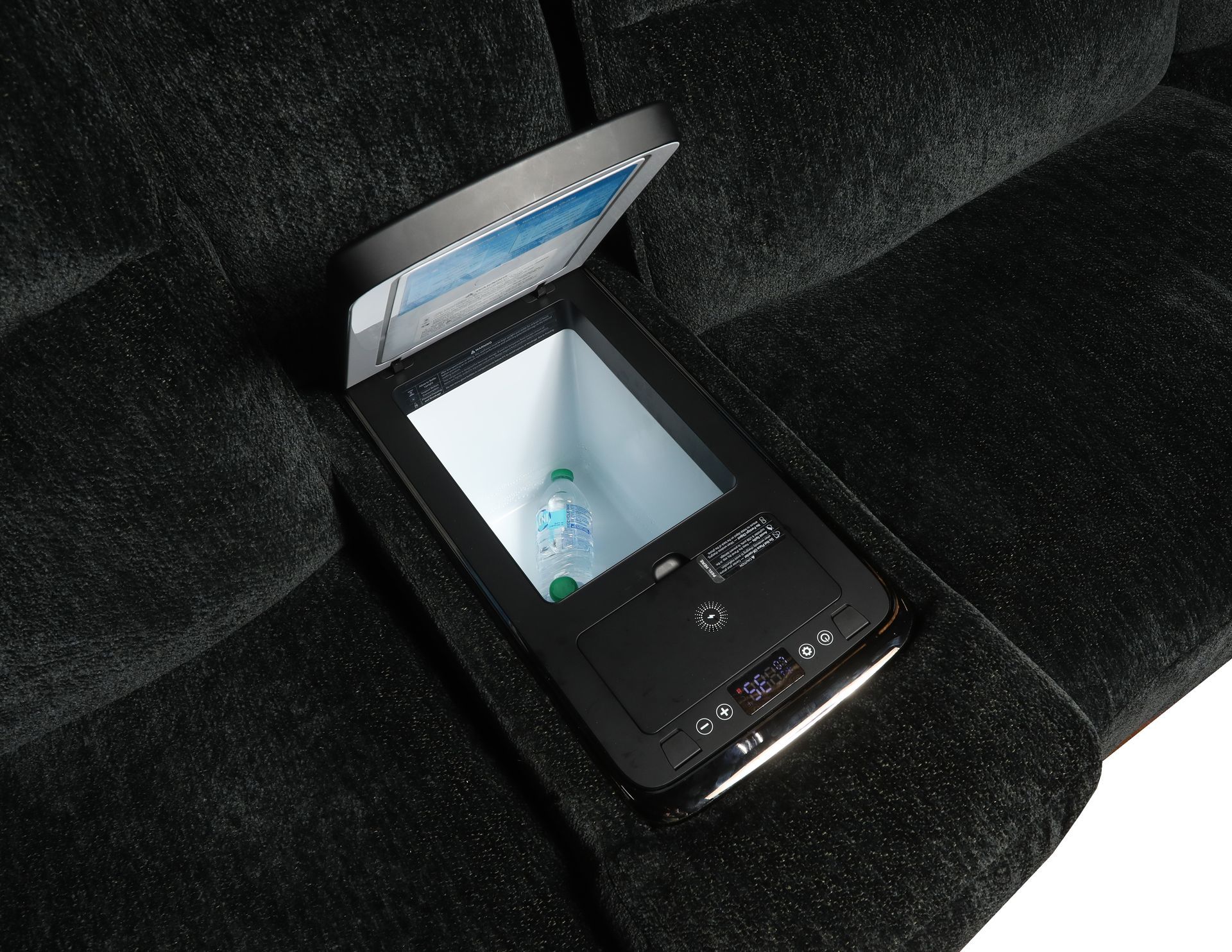 An open, refrigerated storage compartment embedded in the dark fabric armrest of a piece of furniture.