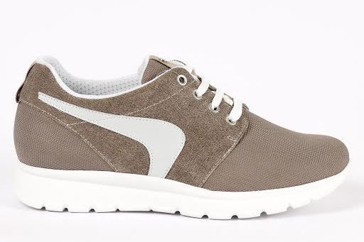 נעלי ספורט חומות עם סוליה לבנה ולוגו צדדי, שרוכים לבנים, על רקע לבן.