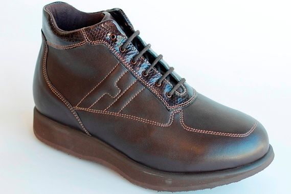 מגף עור חום עם שרוכים ופרטים תפורים, על סוליה חומה.