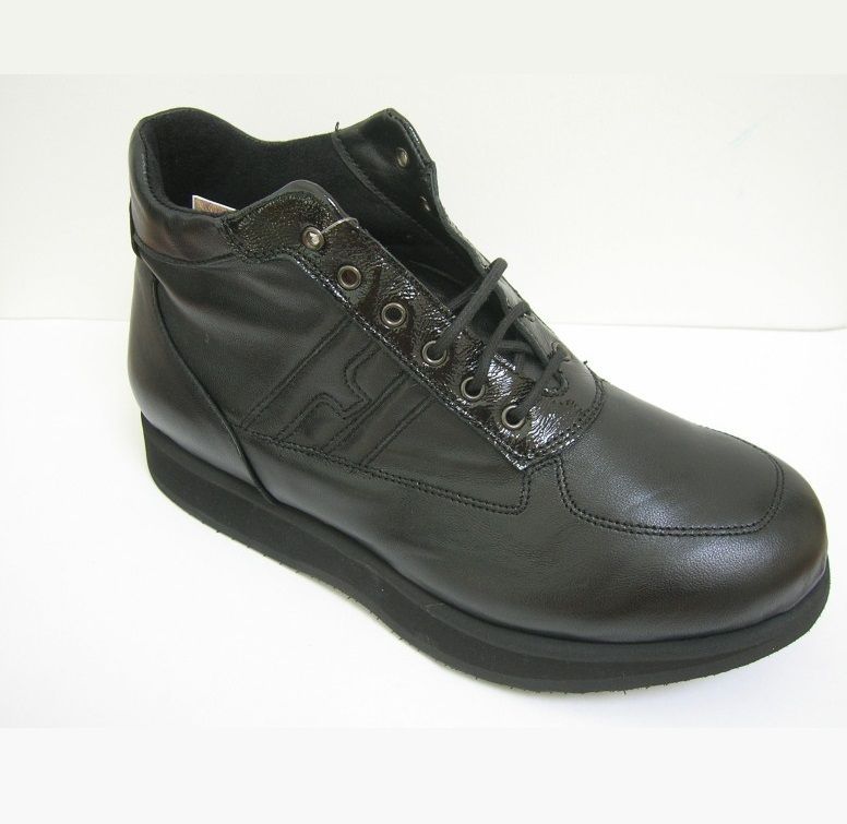 נעל עור שחורה גבוהה עם סוליה שחורה עבה, שרוכים ופרטים דקורטיביים על רקע לבן.