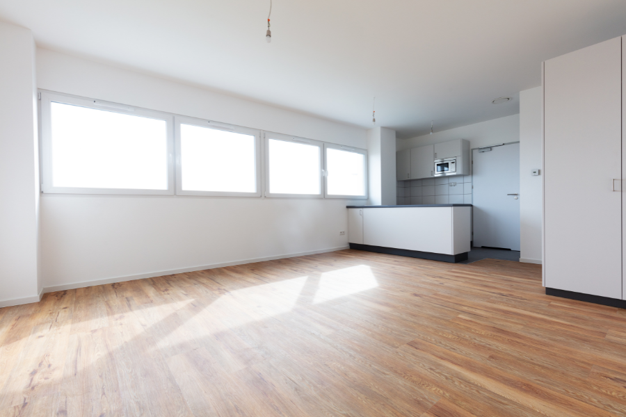 Open room with vinyl flooring and small kitchen