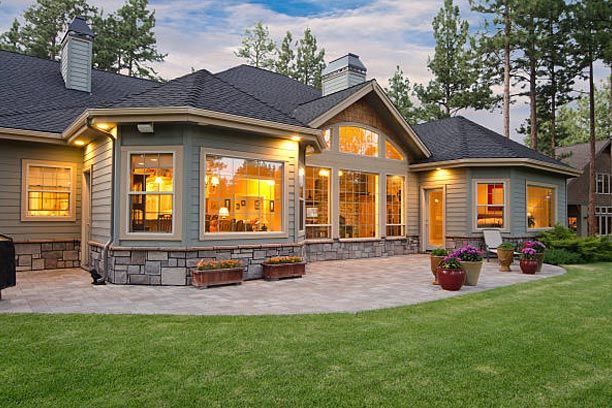 A large house with a lot of windows and a patio in front of it.