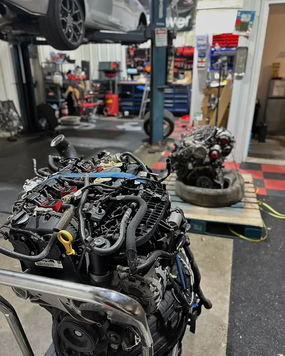 Two car engines in a repair shop | Konstant Autowerks