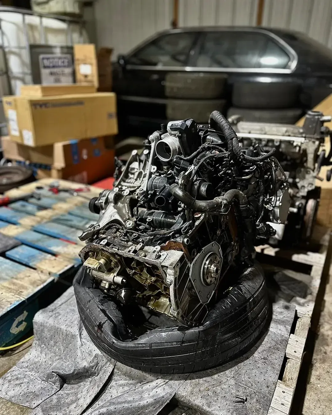 Engine on a pallet, supported by a tire | Konstant Autowerks