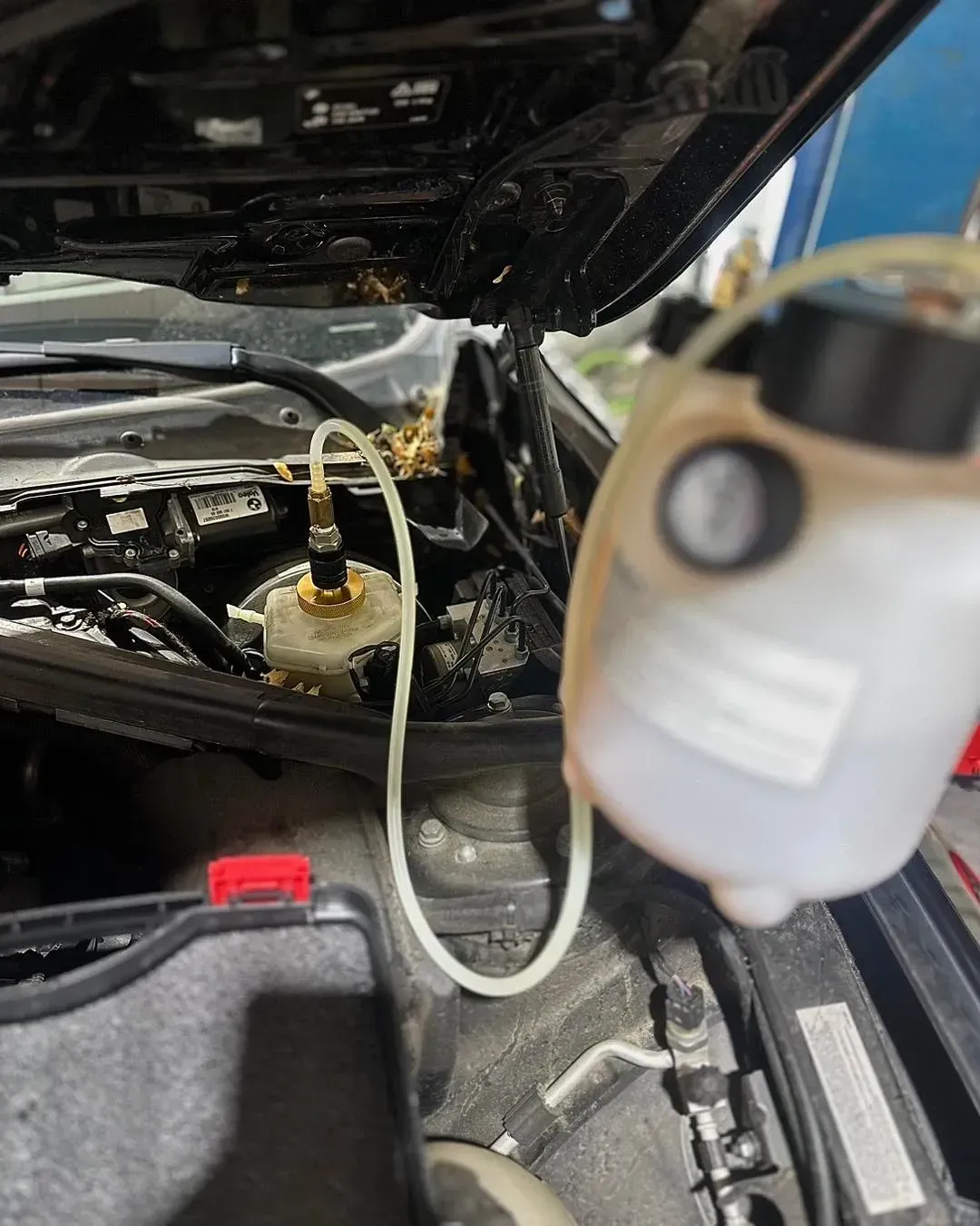 Car engine bay with a clear reservoir connected to the brake system for fluid maintenance | Konstant Autowerks